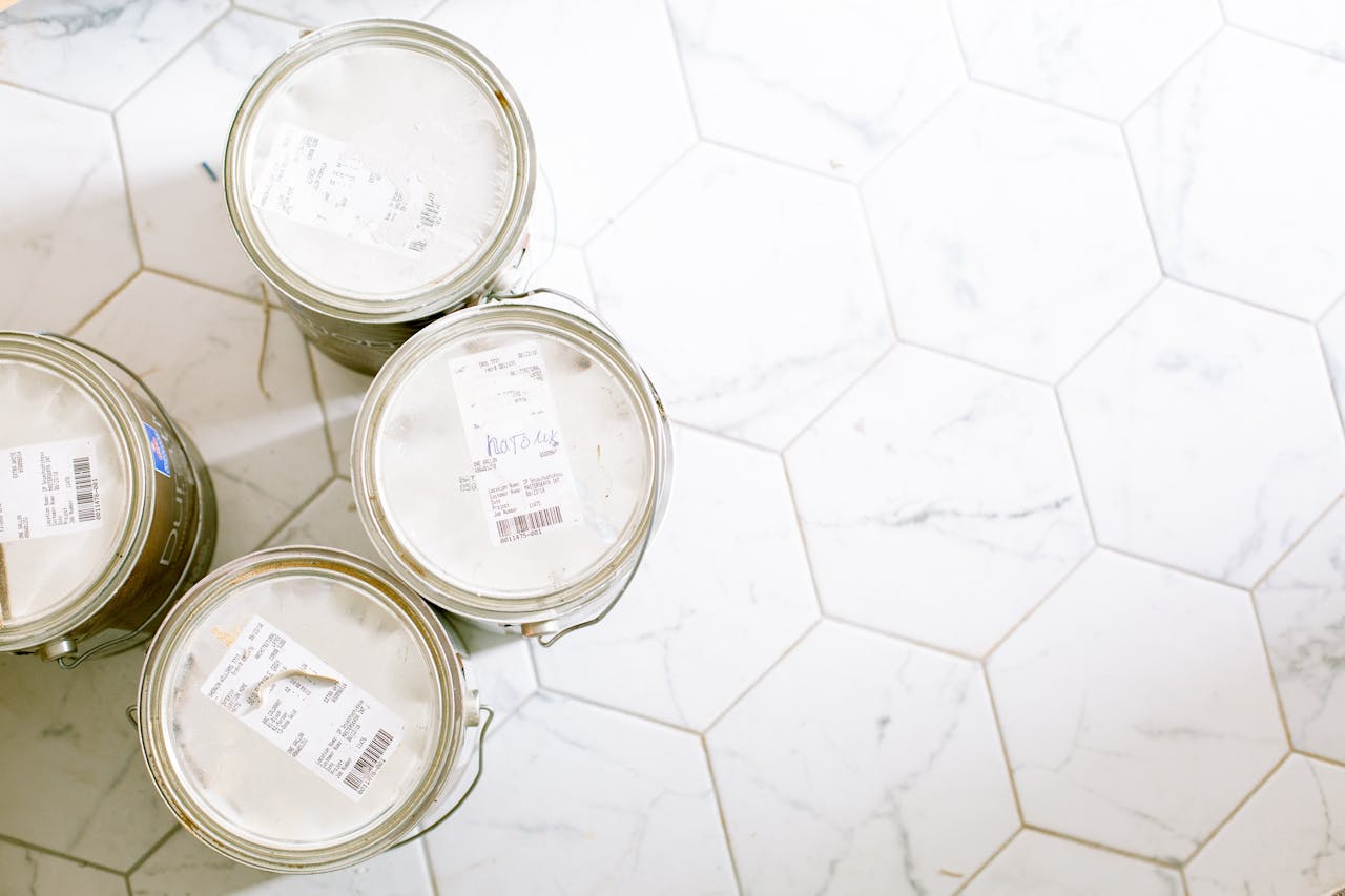 Home Aerial view of paint cans on a hexagonal tile floor, perfect for renovation themes.